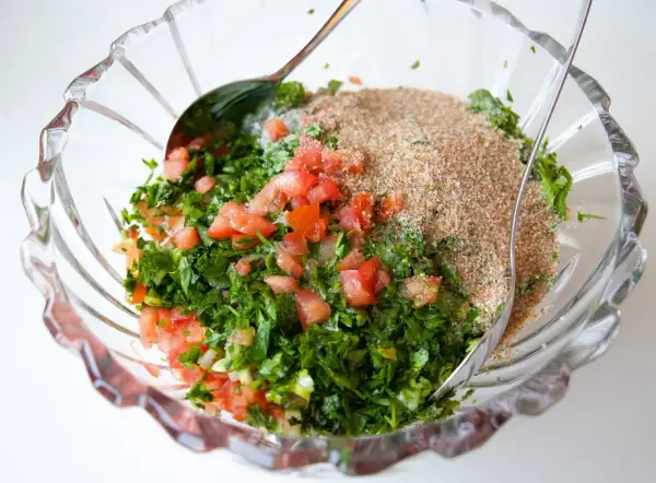 En skål med färska ingredienser för Zeinas tabbouleh: hackad persilja, tomat och bulgur.