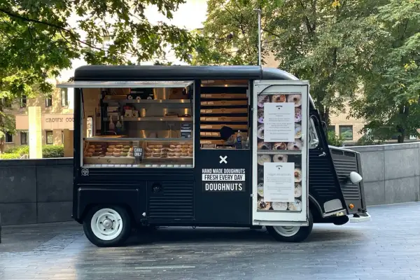 Food truck nero con ciambelle fatte a mano, fresche ogni giorno.