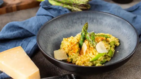 Cremiges Risotto mit frischem Spargel und Parmesan, garniert mit Paprikapulver. Ein Genuss für alle Sinne!