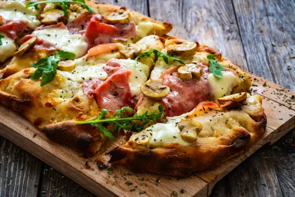 En krispig pinsa med skinka, champinjoner och ruccola. Perfekt för ett snabbt pinsa recept deg.