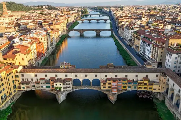 Mostra Ponte Vecchio, jeden z głównych punktów, które warto zobaczyć we Florencji, z kolorowymi budynkami i rzeką Arno.