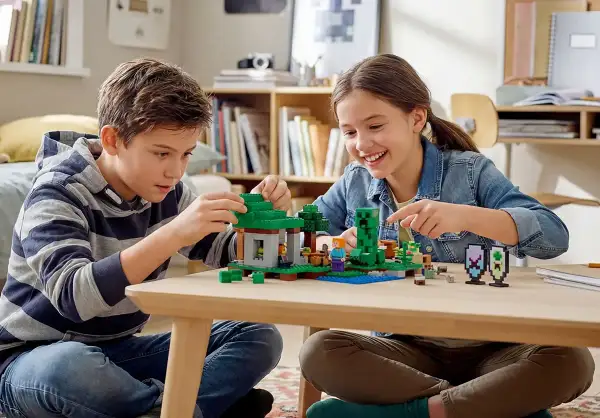 Dzieci budują z klocków Minecraft, tworząc jedną z najlepszych gier LEGO. Radość i kreatywność na twarzach maluchów.