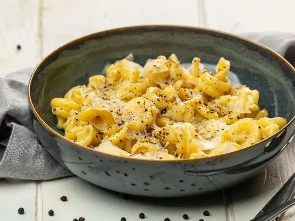 Cacio e pepe: eine Schüssel mit cremiger Pasta, bestreut mit frisch geriebenem Pecorino Romano und schwarzem Pfeffer.