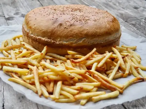 Ogromny burger z sezamem i złociste frytki, gotowe do podania. Ile piec burgery w piekarniku? Ten wygląda na gotowego!
