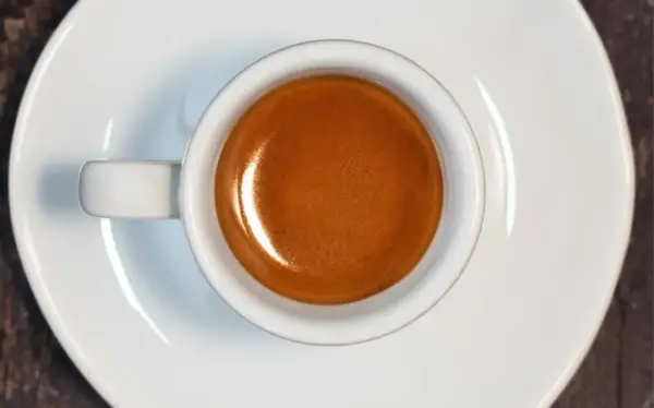 Tazzina di caffè espresso con crema dorata, risultato di un'accurata lavorazione del caffè.