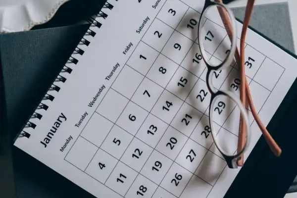Okulary na kalendarzu z napisem "January". Planowanie ważnych terminów, np. Kindergeld termine, wymaga organizacji.