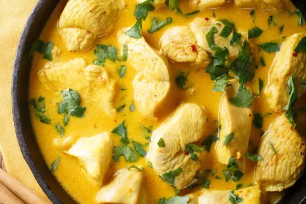 Ein klassisches Curry-Hähnchen-Rezept in cremiger Sauce, garniert mit frischer Petersilie.