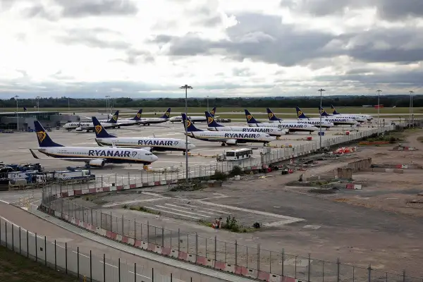 Wiele samolotów Ryanair na płycie lotniska. To typowy widok dla lotnisk w Anglii, gdzie tanie linie lotnicze obsługują duży ruch pasażerski.