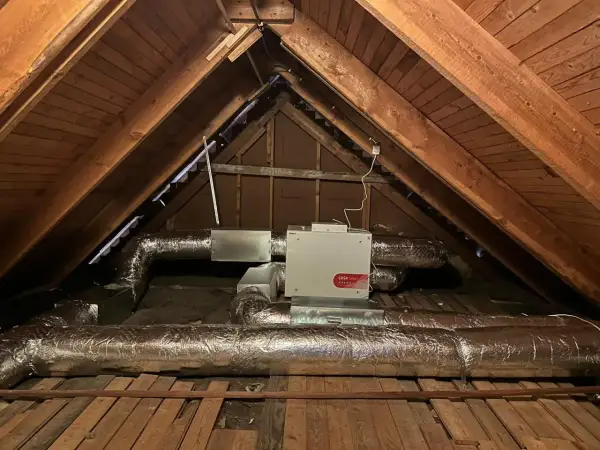 FTX-installation i en vind med isolerade ventilationsrör och en vit enhet märkt "CASA Smart".