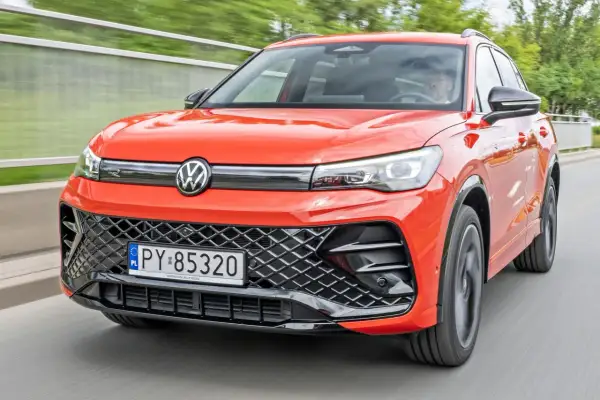 Nowy Tiguan w jaskrawym kolorze jedzie po drodze.