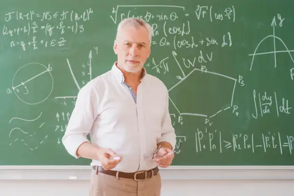 Nauczyciel z tablicą pełną wzorów matematycznych, jakby potrzebował urlop dla poratowania zdrowia po długim semestrze.