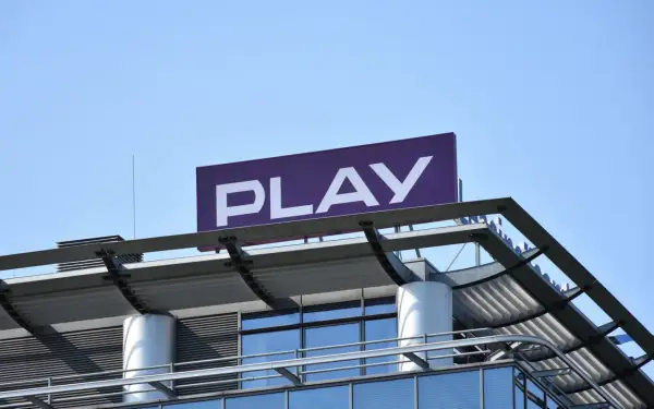 Logo PLAY na dachu budynku. Zastanawiasz się, co to roaming krajowy? To usługa, która pozwala korzystać z sieci innego operatora w Polsce.