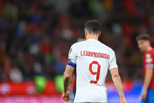 Piłkarz Robert Lewandowski w białej koszulce z czerwonym napisem "LEWANDOWSKI" i numerem 9.