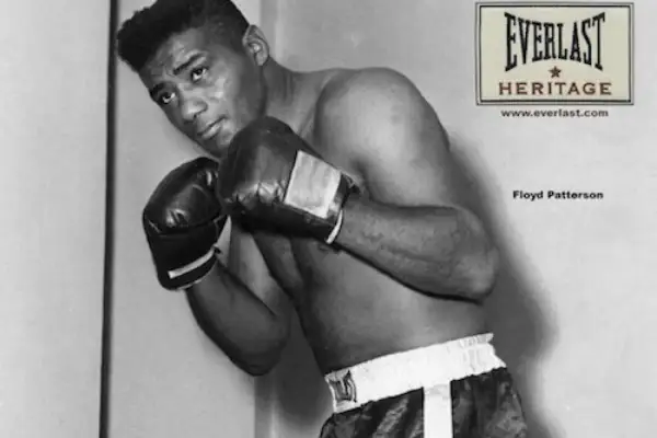 Floyd Patterson, a legendary boxer, poses in the ring, his record etched in boxing history.