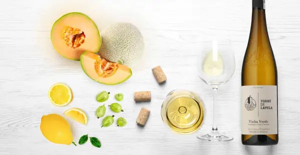 Letnia kompozycja z melonem, cytryną, agrestem i kieliszkiem orzeźwiającego **vinho verde**.