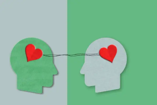 Twee profielen met harten verbonden door lijnen, symboliseren autisme en empathie.