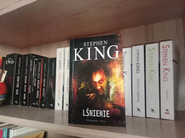 Półka z książkami Stephena Kinga, w tym "Lśnienie", "Cmętarz zwierząt" i "Nocna zmiana".
