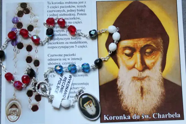 Koronka do św. Charbela, z kolorowymi paciorkami i medalikiem, obok wizerunku świętego. Idealna do odmawiania litanii do św. Charbela 9 dni.