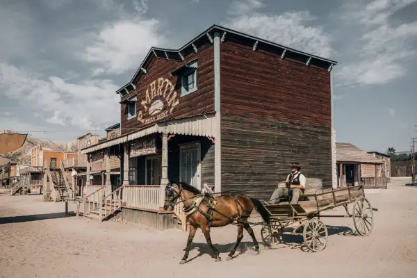 Un vaquero conduce un carro tirado por caballos por un pueblo del Salvaje Oeste en el desierto de Tabernas y Oasys Minihollywood.