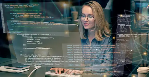Frau lernt Programmieren im Fernstudium. Sie arbeitet konzentriert an ihrem Computer, um Fachinformatiker zu werden.