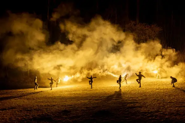 Silvia Gallerano e un gruppo di persone danzano tra fumo e bengala, creando un'atmosfera magica e un po' caotica, quasi come se stessero scacciando "la merda" della vita.