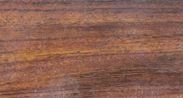 Textura rica de madera mongoy, con vetas oscuras y tonos dorados que evocan la naturaleza.