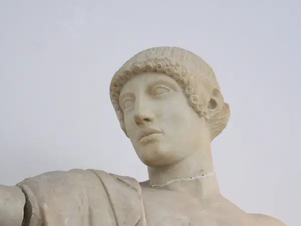 Buste en marbre d'Apollon, dieu grec ou romain, aux boucles caractéristiques et au regard pensif.