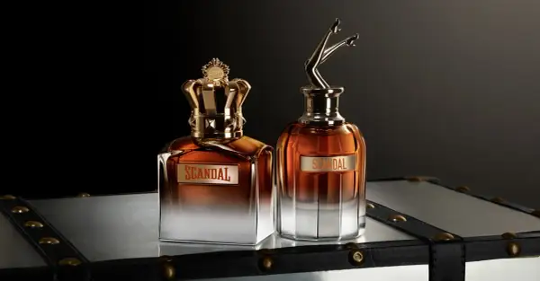 Dwa flakony perfum Jean Paul Gaultier Scandal Meski: jeden z koroną, drugi z nogami w szpilkach.