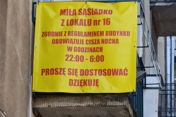 Żółty baner informuje miłą sąsiadkę z lokalu nr 16, że zgodnie z regulaminem budynku obowiązuje cisza nocna w godzinach 22:00-6:00.