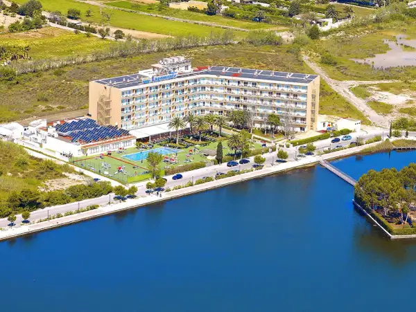 Hotel Tui Suneo Lagomonte z basenem i panelami słonecznymi, położony nad błękitną wodą.