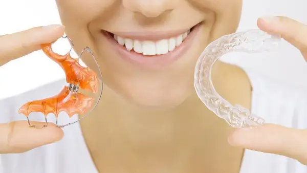 Uśmiechnięta twarz z aparatem ortodontycznym i przezroczystymi nakładkami. Dr Smile oferuje rozwiązania dla pięknego uśmiechu.