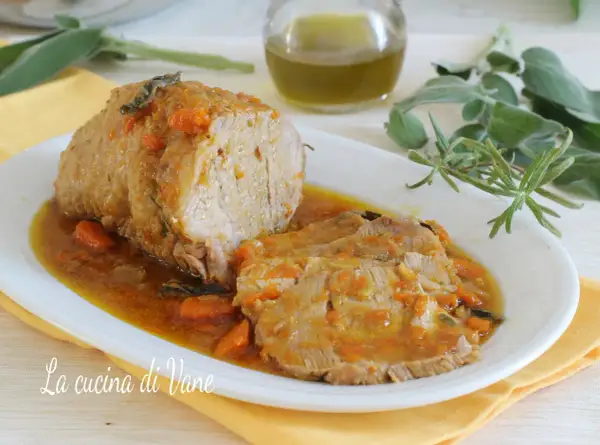 Succulento arrosto di vitello al forno, affettato e servito in un sughetto saporito con carote e erbe aromatiche.