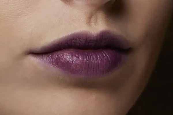 Labbra con rossetto viola intenso, un colore audace che dona a chi osa sperimentare.