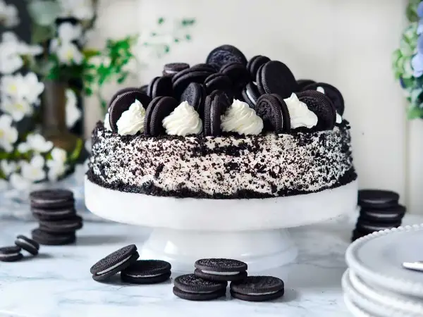 En imponerande oreo tårta, täckt med krossade kakor och dekorerad med hela oreos och fluffig grädde. Perfekt för alla kakälskare!