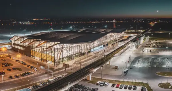 Nowoczesny terminal lotniska w Gdańsku nocą. Widok z góry pokazuje parkingi, drogi i tory kolejowe, ułatwiając planowanie, jak dojechać na lotnisko w Gdańsku.