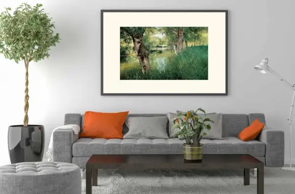 A modern impressionism painting of a serene riverbank with lush green grass and trees, framed above a grey sofa with orange and grey cushions.