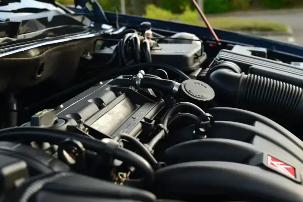 Gros plan sur le moteur d'une voiture, avec le bouchon du voyant d'huile moteur visible.