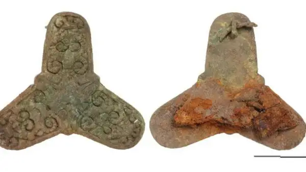 Zwei bronzene Artefakte, ein gut erhaltenes mit Verzierungen, das andere stark verrostet, stammen aus einem Wikinger Grab.