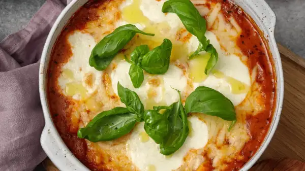En ugnsbakad gnocchi alla sorrentina med smält mozzarella, tomatsås och färsk basilika.