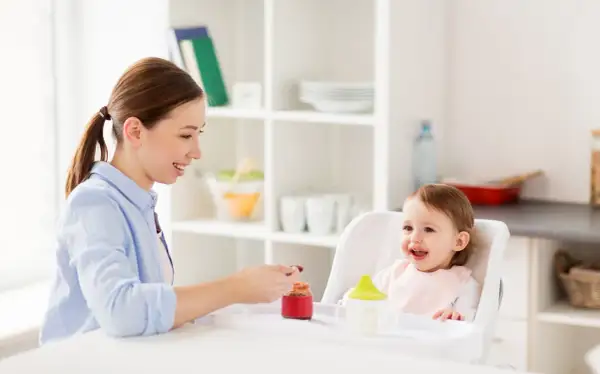 Mama karmi roczne dziecko, które z radością je. To pokazuje, ile powinno jeść roczne dziecko.