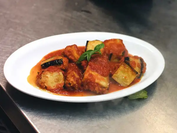Friterad aubergine i tomatsås, toppad med färsk basilika. En läcker italiensk rätt.