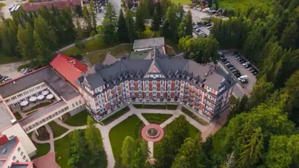 Wojskowy dom wypoczynkowy w Kościelisku, otoczony zielenią, z charakterystyczną architekturą i zadbanym ogrodem.