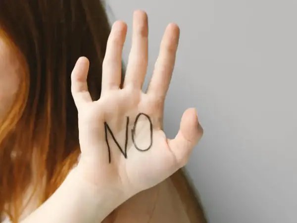 Dłoń z napisem "NO" symbolizuje trudny związek z osobą chorą na nerwicę, potrzebę postawienia granic.