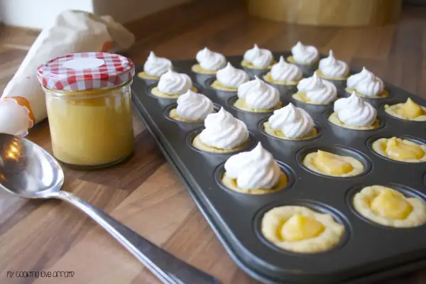 Kleine Törtchen mit Baiserhauben und einer Füllung aus Lemon Curd, bereit für köstliche Rezepte mit Lemon Curd.