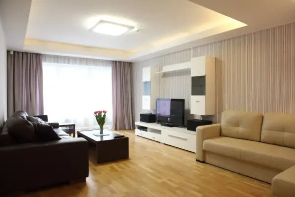 Nowoczesny salon z dwupoziomowym sufitem podwieszanym i wbudowanymi lampami.