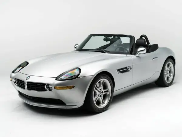 Srebrny kabriolet BMW Z8 na białym tle, z czarnym dachem i wnętrzem. Klasyk motoryzacji.
