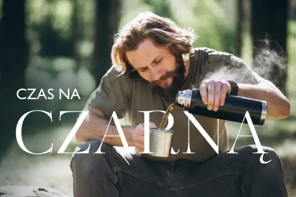 Mężczyzna z brodą nalewa czarną herbatę do kubka w lesie. Od kiedy dla dziecka?