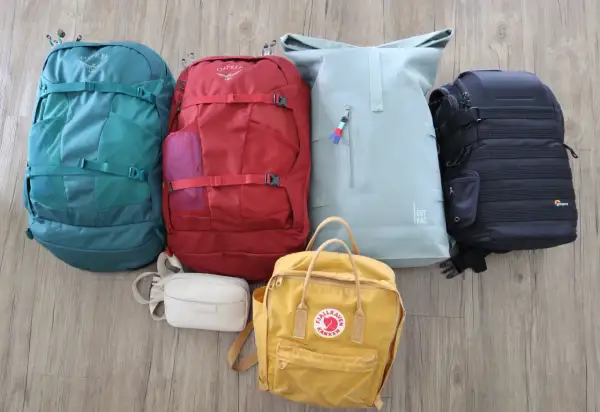 Sechs Rucksäcke in verschiedenen Farben und Größen, bereit für eine Weltreise und Backpacking.