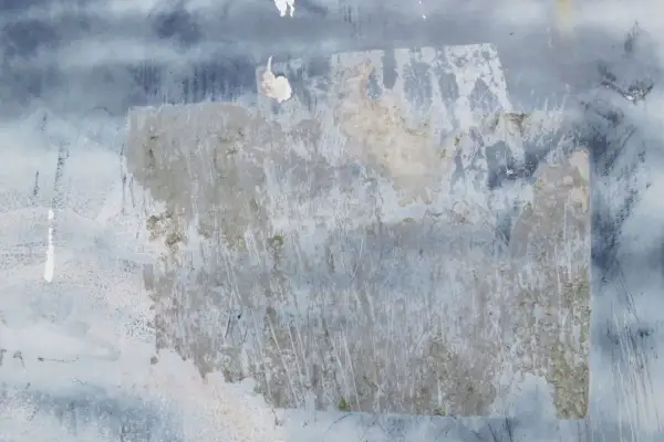 Texture de papier peint foncé avec des traces de colle à enlever, révélant des zones plus claires et des éraflures.