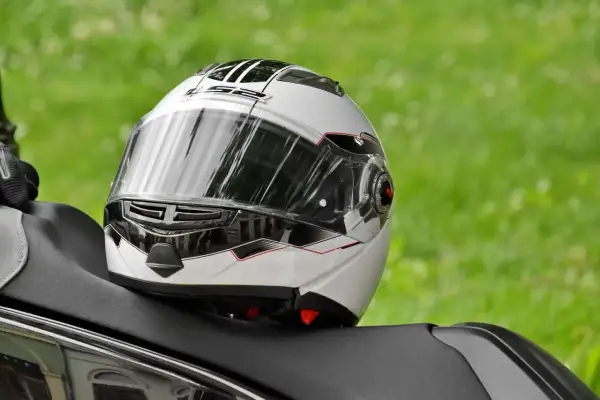 Biały kask motocyklowy z czarnymi i czerwonymi akcentami, gotowy do naprawy.